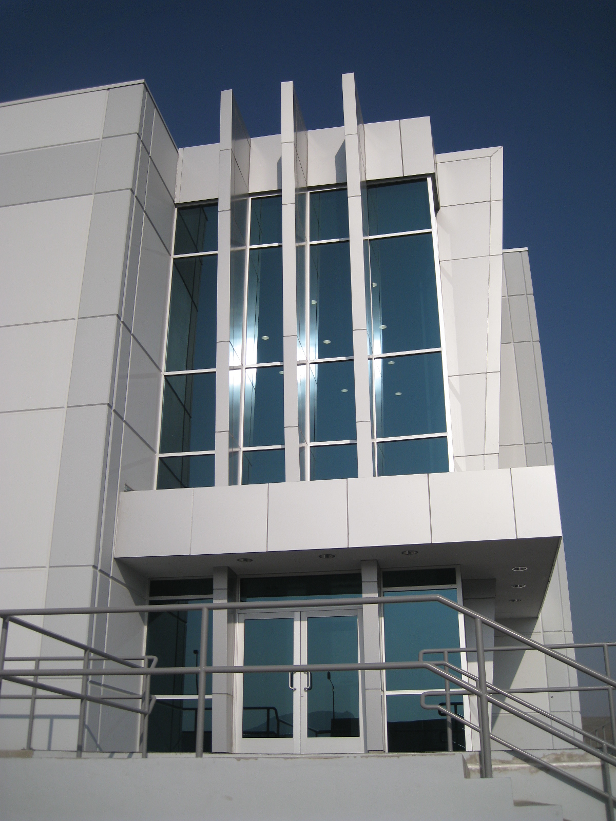 Muro cortina y acceso principal comercial en cristal de doble altura